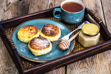 Fototapeta na wymiar Pancakes with honey on vintage bowl on wooden tray
