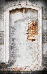 Old vintage cracked and damaged niche or blind window on historical architecture building facade made of brick and concrete as background