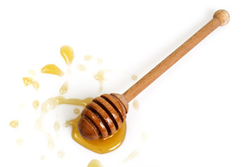 Freshly fragrant honey into a bowl and dipper on white backgroun