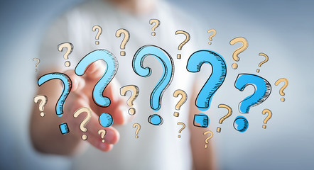 Businessman touching hand drawn question marks with his fingers
