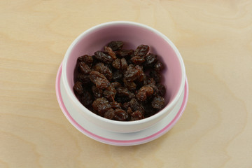 Raisins in small condiment bowl and saucer