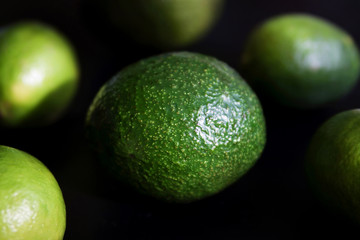 avocado and limes on a black background