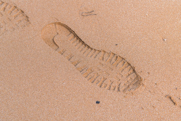 Footprints on the sand near the waves
