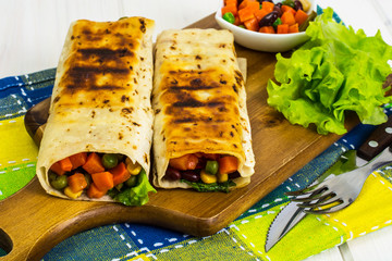 Buritos for Mexican on wooden cutting board