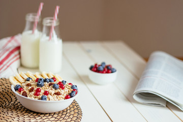 Healthy breakfast with berries and milk on the white wooden table