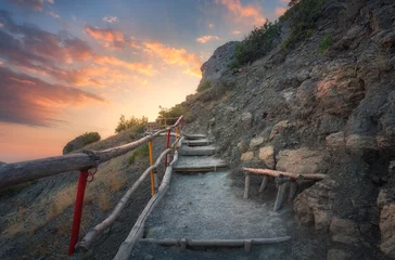 Gordijnen Stone stairs with wooden railing in the mountains at sunset. Landscape with mountain path and rocks against colorful blue sky with clouds. Trail leading to the mountain peak. Adventure and travel   © den-belitsky