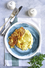 Fried pork chop with caramelized onion garnished with mashed potato.Top view.