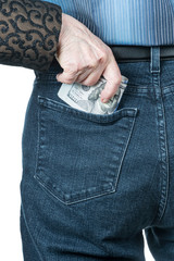 Senile hand puts dollars in the back pocket of jeans man, isolated on white background