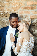 Loving couple of cute bride and african American groom