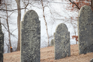 old gravestones with moss growing on them overlooking a lake