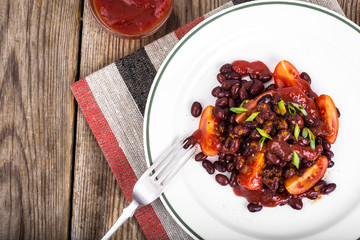 Red beans, tomatoes, ketchup, onion and spices on the white plat
