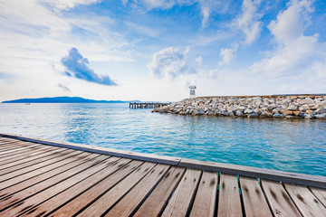 Wooden plank pier with seascape and bright blue sky