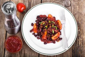 Red beans, tomatoes, ketchup, onion and spices on the white plat