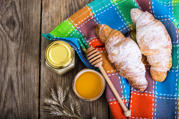 Croissants with powdered sugar on background of old boards