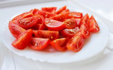Fresh tomato sliced ​​on a white plate