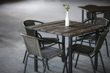 Bright green bouquet of wild flowers in a stylized vase-bottle on the table cafe.