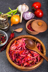 Salad of cabbage, carrots, beets and butter in a wooden bowl, re