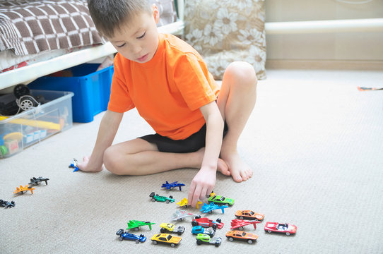 boy playing with car collection on carpet.Child play home. Transportation, airplane, plane and helicopter toys for children, miniature models