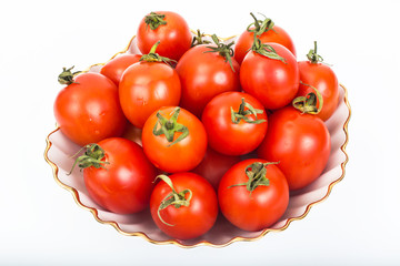 Fresh small tomatoes in white salad bowl