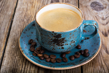 Espresso coffee in blue cup on vintage wooden background