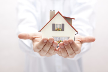 Small toy house in hands