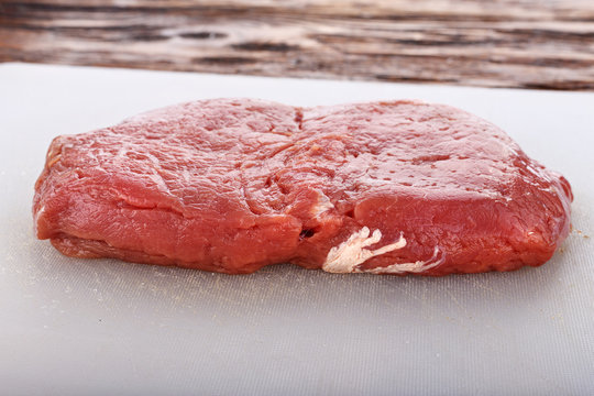 raw steak on a white board