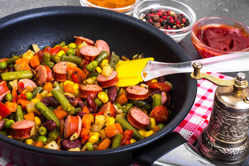 Mexican mix of vegetables with sausages in pan