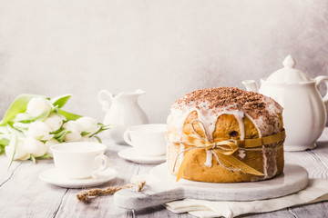 Easter orthodox sweet bread, kulich and colorful quail eggs with white tulips. Holidays breakfast concept with copy space. Retro style toned.