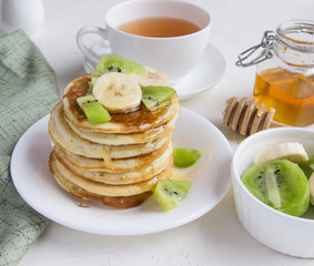 Delicious pancakes with banana, kiwi and honey.