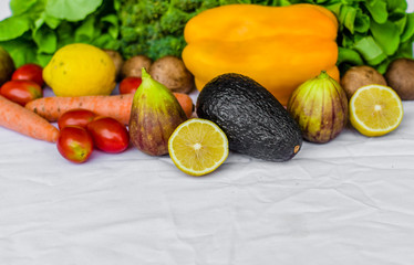 Close up photo of fresh fruit and vegetables, grains, and nuts on a white background. Concept of cooking and eating healthy food, fitness, vegetarian and vegan, and lifestyle.