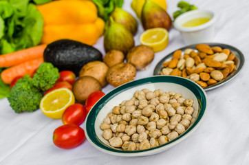 Close up photo of fresh fruit and vegetables, grains, and nuts on a white background. Concept of cooking and eating healthy food, fitness, vegetarian and vegan, and lifestyle.