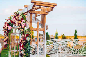 Wedding flower composition for guests and newlyweds tables. Wedding arch and flowers decor.