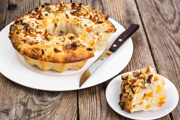 Cake with nuts and dried apricots on wooden background