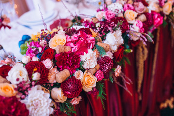 Wedding flower composition for guests and newlyweds tables. Wedding arch and flowers decor.
