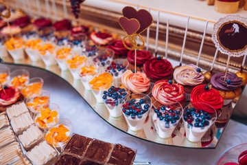 Wedding candy bar with makaroons and fruits.