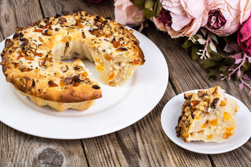 Cake with nuts and dried apricots on wooden background
