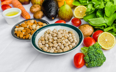 Close up photo of fresh fruit and vegetables, grains, and nuts on a white background. Concept of cooking and eating healthy food, fitness, vegetarian and vegan, and lifestyle.