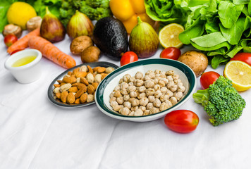 Close up photo of fresh fruit and vegetables, grains, and nuts on a white background. Concept of cooking and eating healthy food, fitness, vegetarian and vegan, and lifestyle.