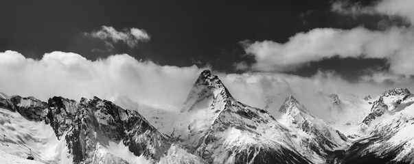 Black and white panorama of snowy mountains in clouds