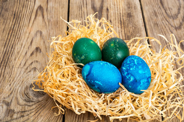 Easter colored eggs, straw, flowers