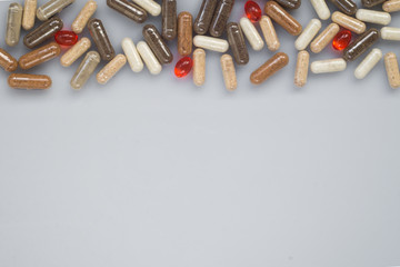 Different medicinal capsule spill out on light surface