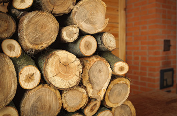 round oak firewood stacked near the stove