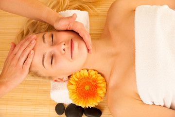 Obraz na płótnie Canvas Beautiful blonde woman having a face massage in spa salon
