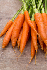 Fresh and sweet carrot on a grey wooden table.