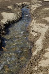 Mountain stream surrounded by sand