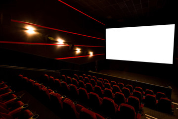 Cinema hall, white screen with copy space and empty armchairs. Movie theatre