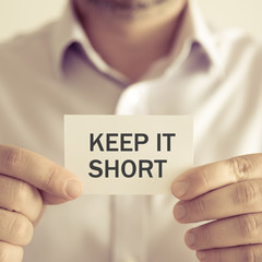 Businessman holding KEEP IT SHORT message card