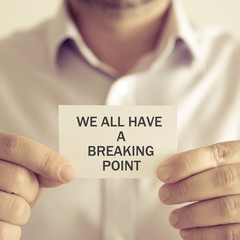 Businessman holding WE ALL HAVE A BREAKING POINT message card