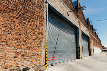 Entrance to a factory with sign "Attention. Entrance and exit of trucks" in Spanish © simonmayer