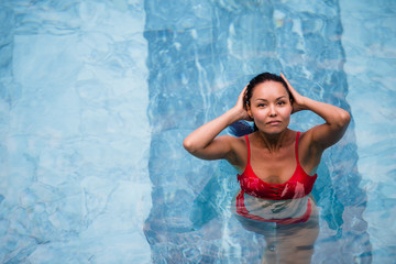 Enjoying vacation. Smiling beautiful young woman in swimming pool.